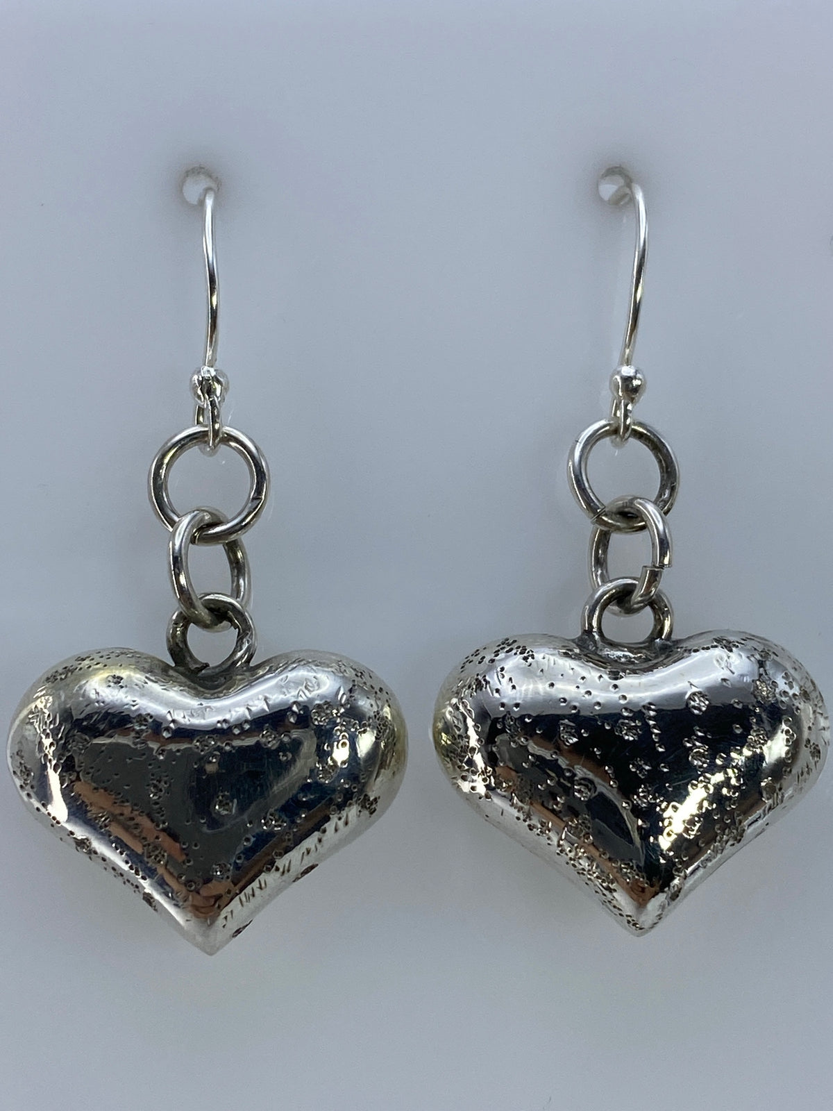 Aretes de corazón plata 925 sobre regla métrica mostrando largo de 3.7 cm