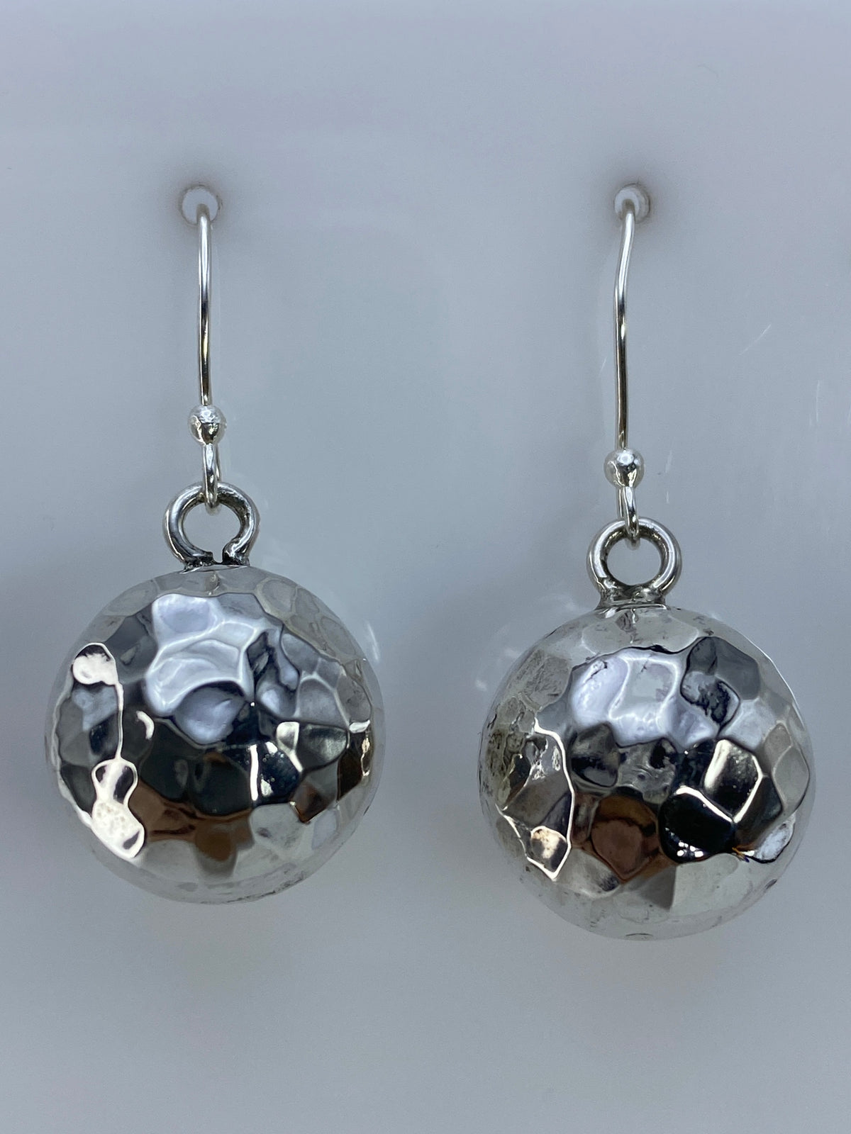 Aretes sobre regla métrica: largo de 3.1 cm desde gancho hasta base