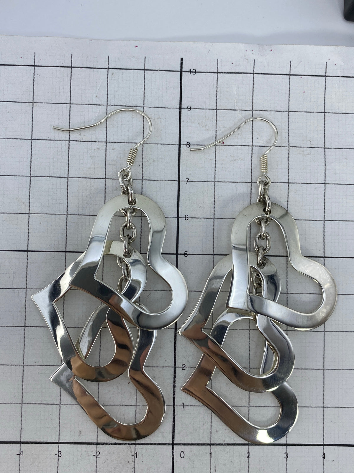 Aretes sobre fondo neutro con el Quinto 925 visible en la plata