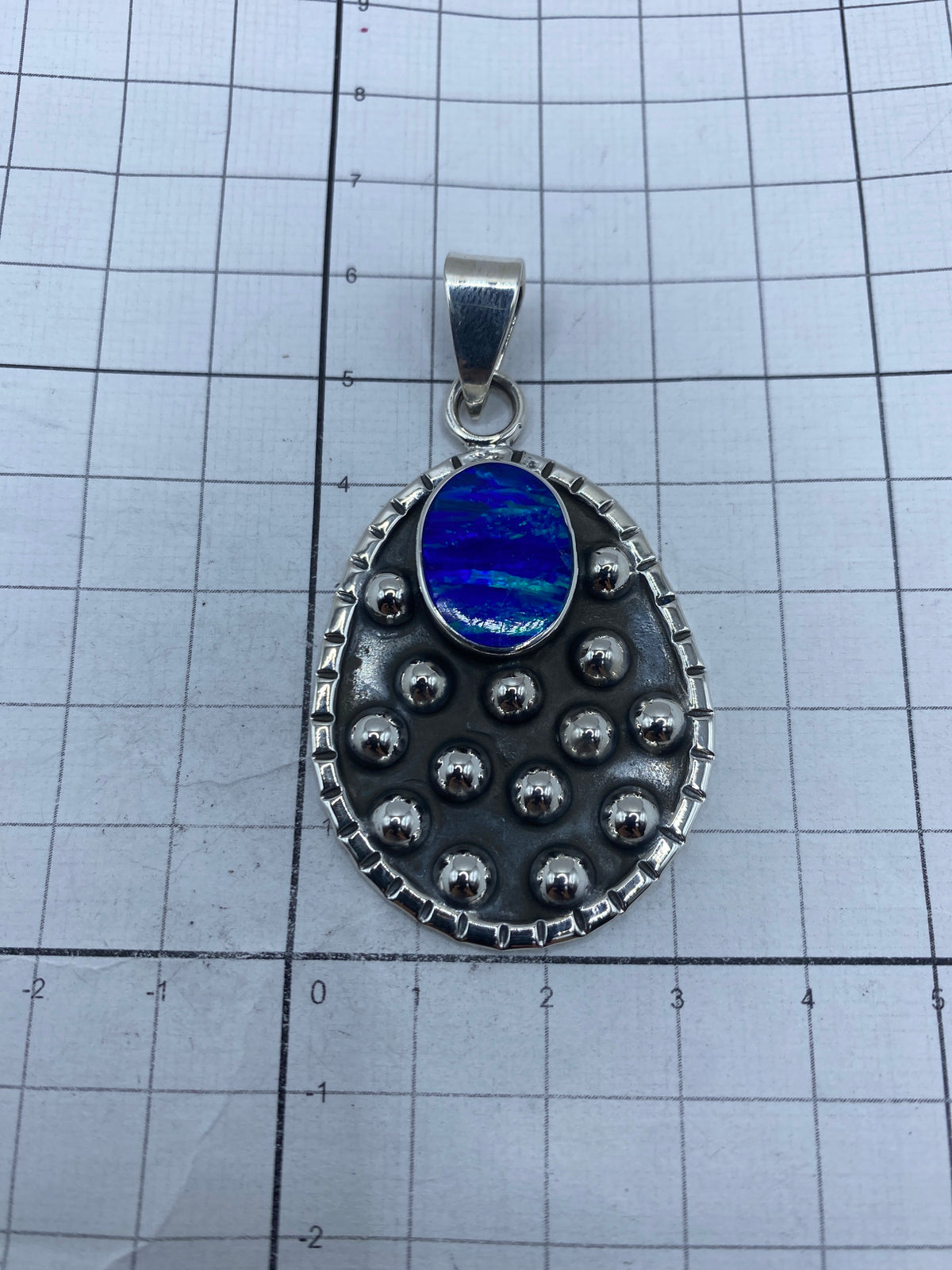 Medida del dije junto a regla: 6.1 cm de largo, con Quinto 925 grabado