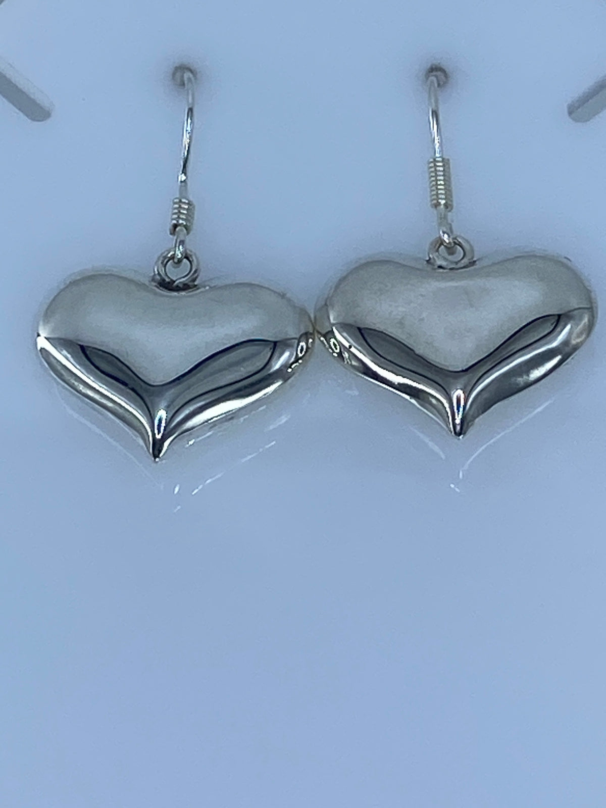 Par de aretes de plata con forma de corazón cartoneado, brillante, colgando de ganchos de plata