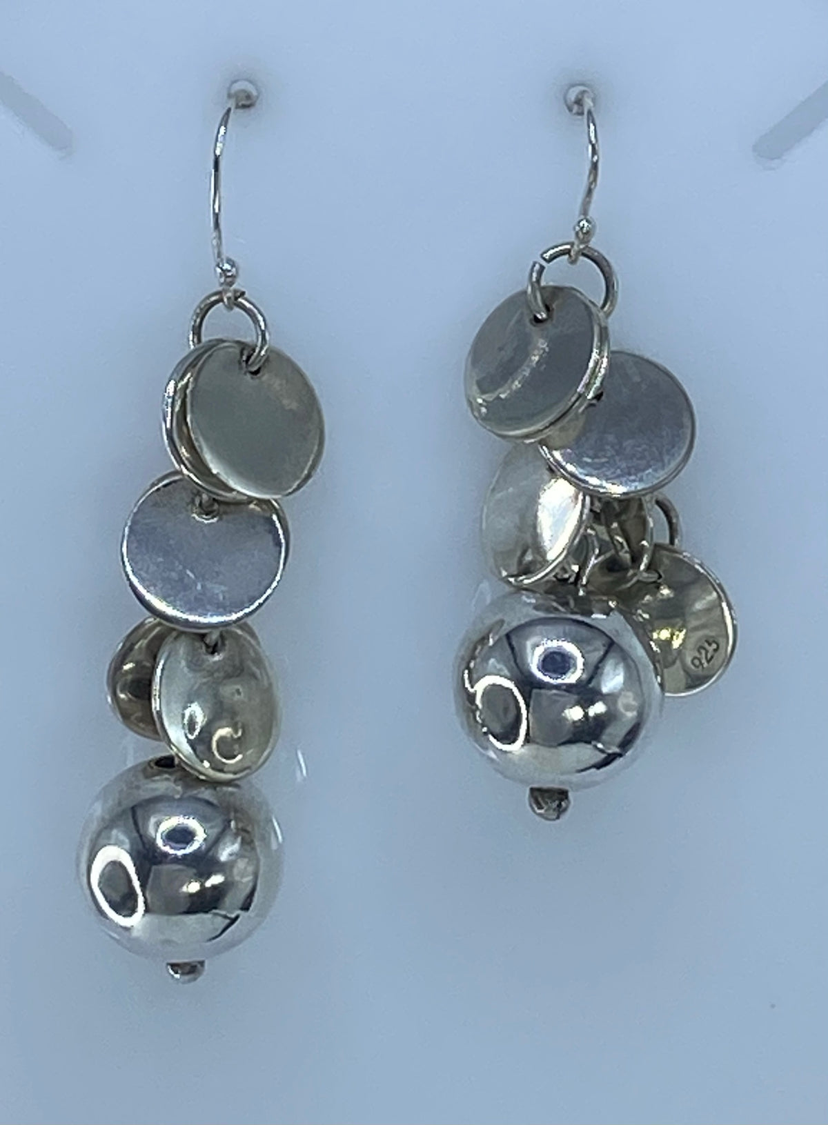 Aretes colocados en la oreja mostrando el largo de 5.7 cm y el movimiento de volumen