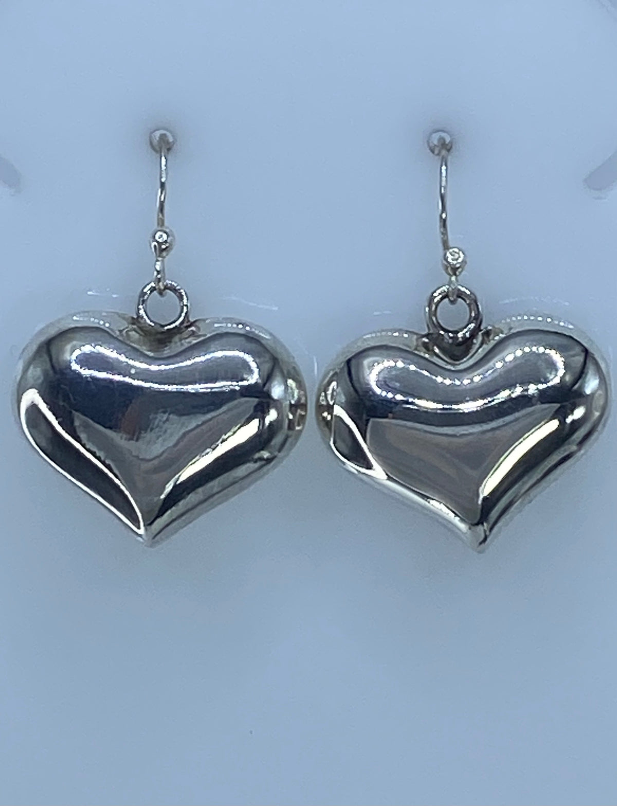 Aretes de plata corazón de 3 cm sobre regla de medición