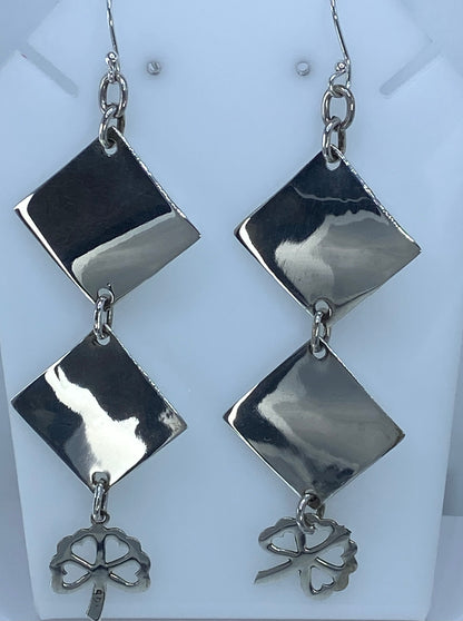 Aretes geométricos sobre fondo blanco mostrando el brillo de la plata 925