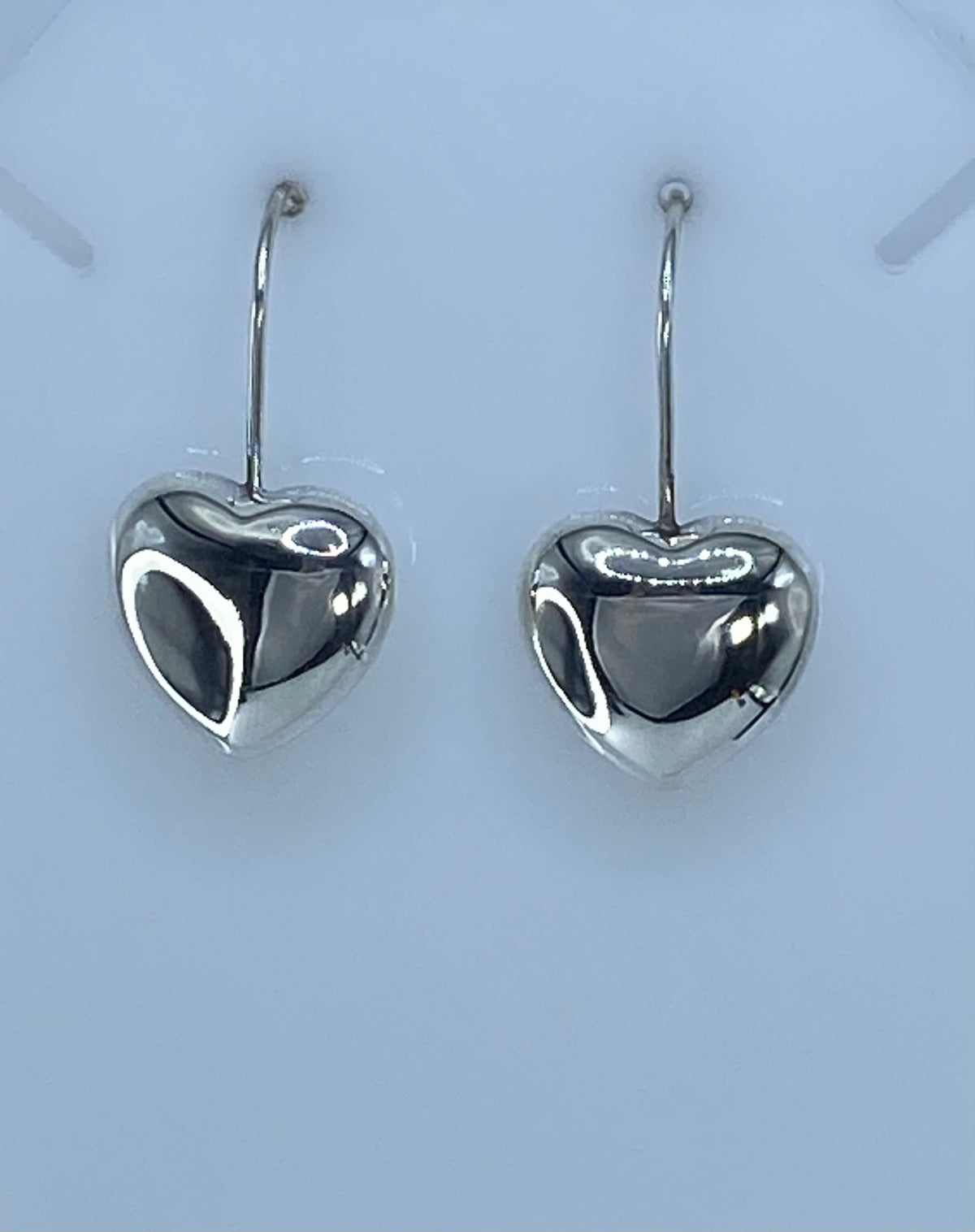 Aretes cartoneados de plata vistos en escala — largo 3.2 cm, diseño minimalista