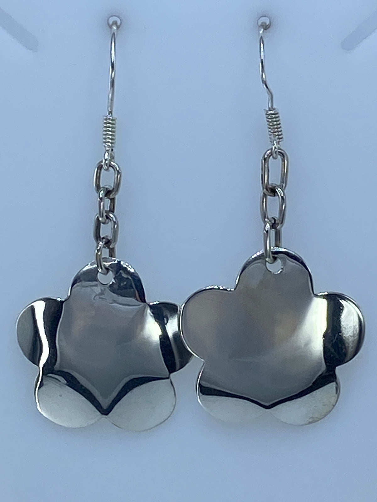 Aretes de plata calado floral, diseño geométrico, vistos de frente en par