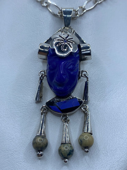 Dije de plata repujado con lapislázuli azul, perfil de K'inich Janaab' Pakal en relieve profundo