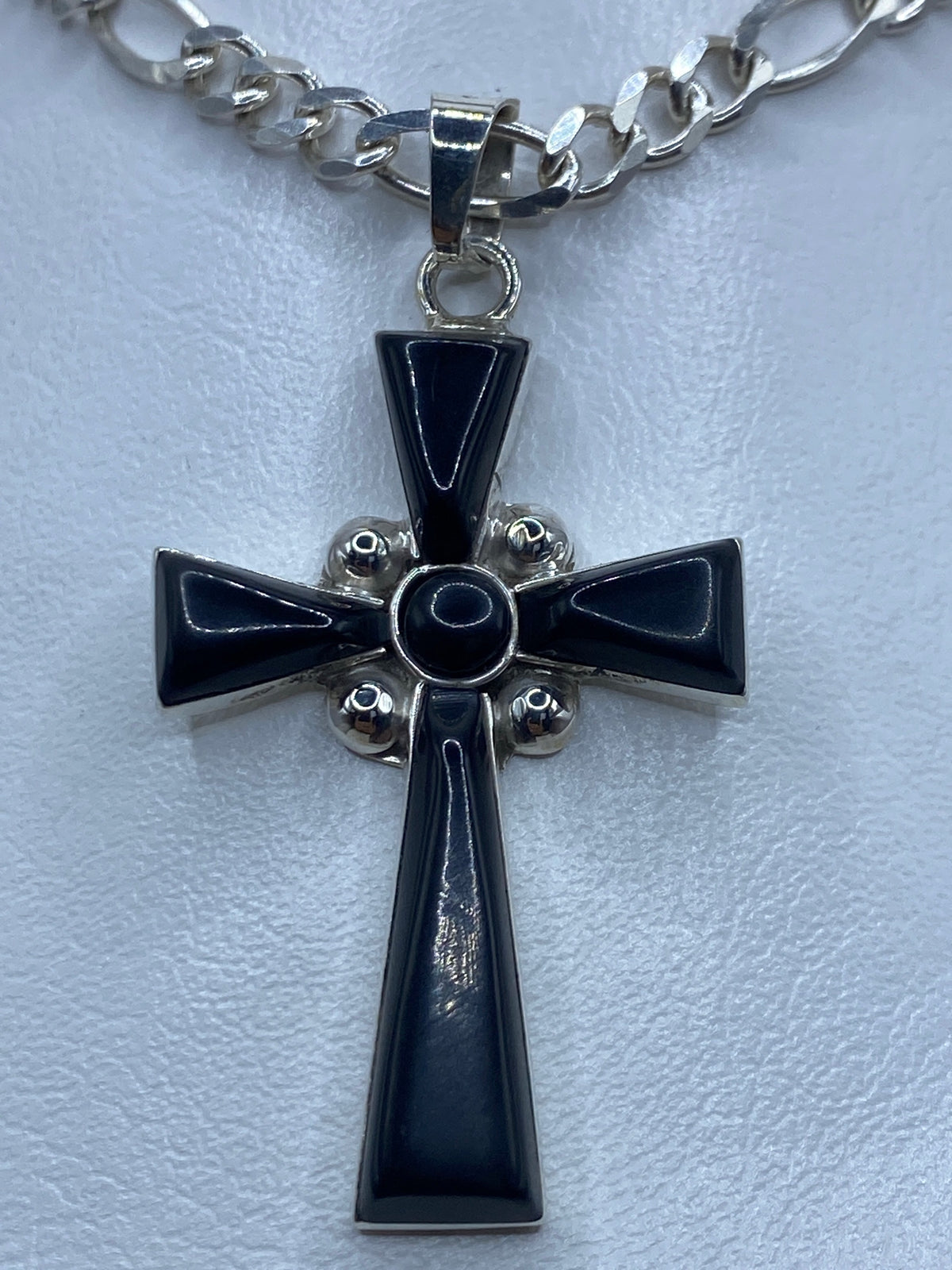 Cruz de plata con ónix negro engastado, sobre cadena eslabón plateada