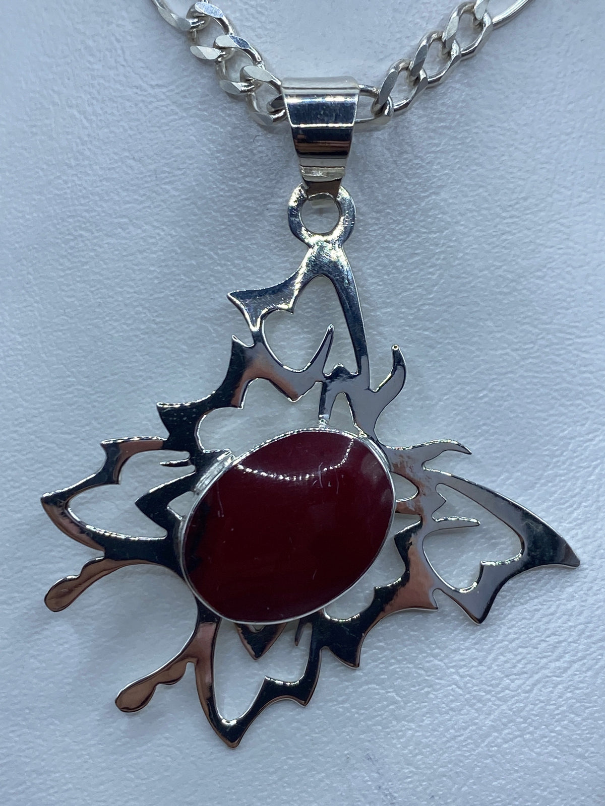 Dije de mariposa de plata 950 con coral rojo engastado, visto desde el frente