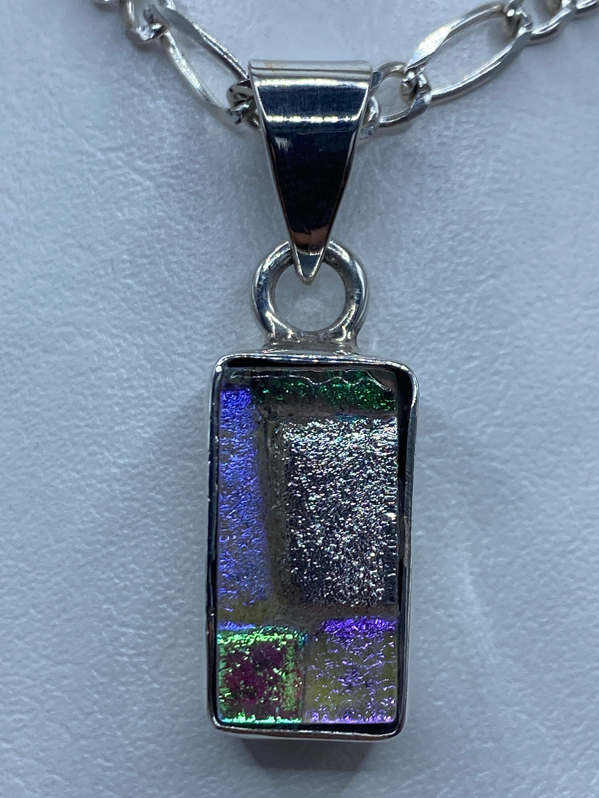 Dije rectangular de plata con incrustación multicolor: azul, verde, morado y gris