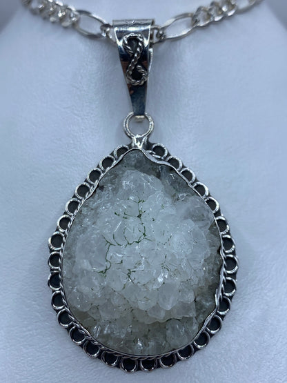 Dije de plata 950 con cuarzo natural engastado, colgando de cadena de plata figaro