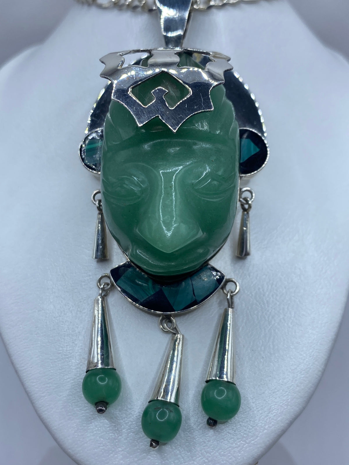 Dije escultural de plata 950 con jade y malaquita verde, con rostro tallado, visto al frente