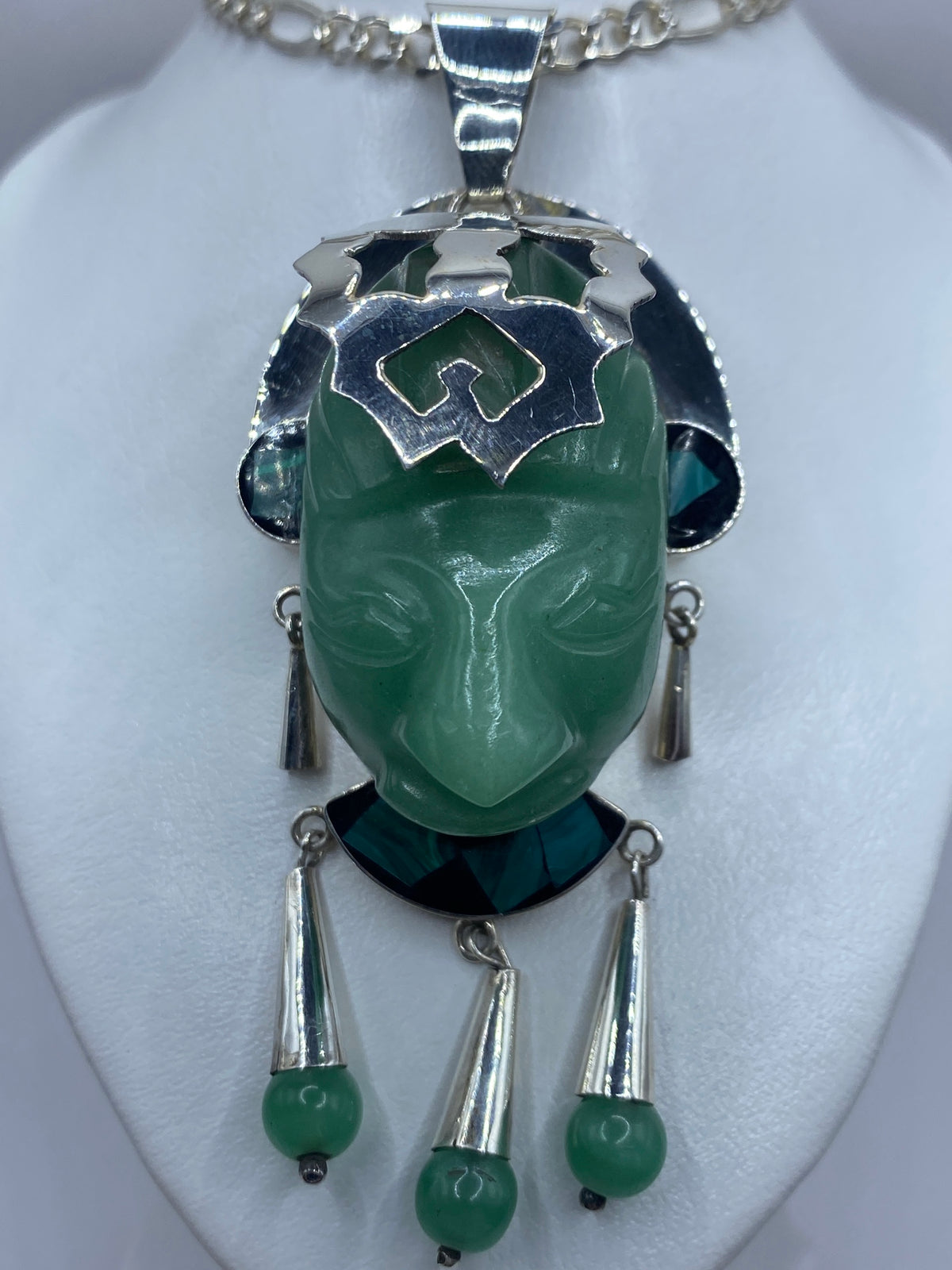 Dije de jade y malaquita en verde sobre cadena de plata, luciendo en el cuello