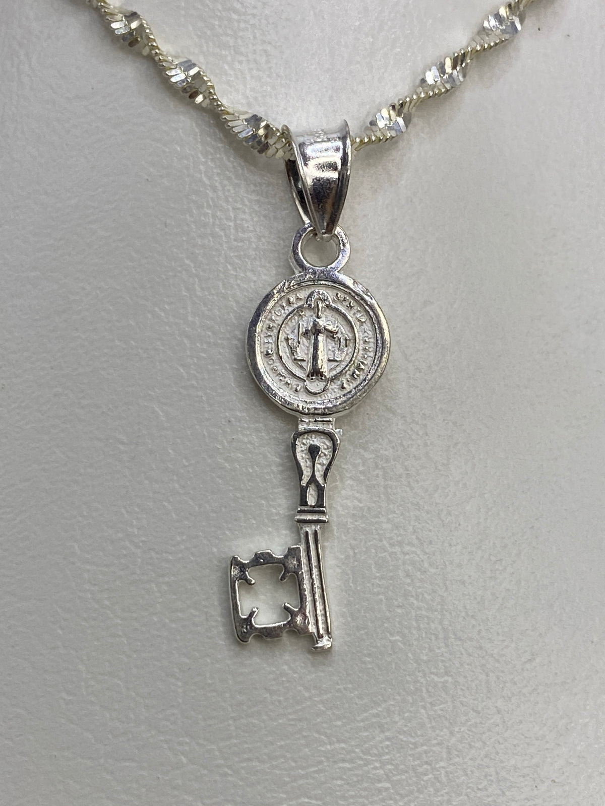 Anverso y reverso de la Medal de San Benito en plata pulida