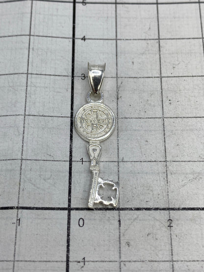Dije Medal de San Benito sobre rejilla de medición mostrando 3.2 cm de largo