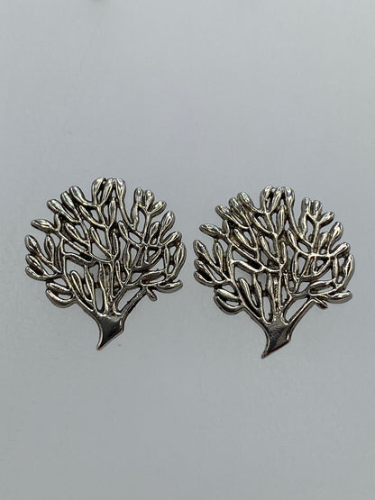 Par de aretes de plata en calado con diseño floral ramificado, sobre fondo gris