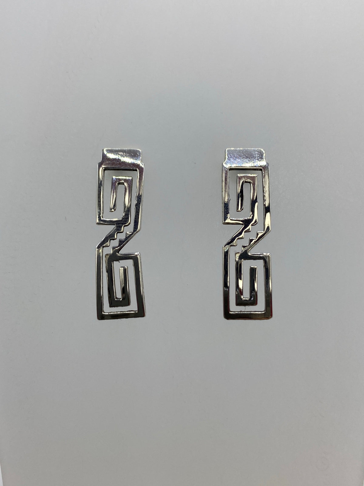 Detalle frontal de los aretes mostrando los rectángulos concéntricos cortados