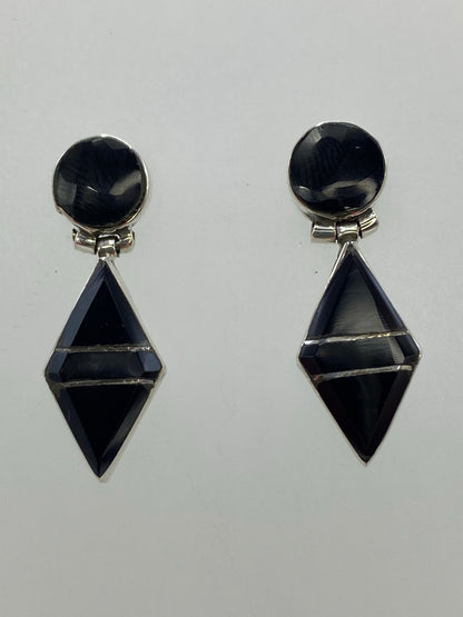 Par de aretes de plata con ónix negro en diseño geométrico esfera-diamante, vista frontal