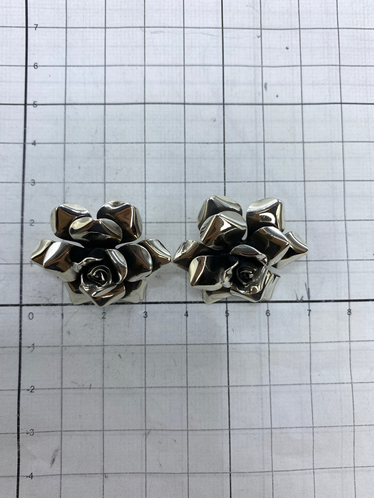 Aretes de plata floral sobre fondo neutro, 2.9 × 2.7 cm, marcados con Quinto 925