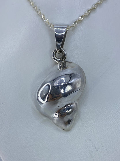 Dije de caracol de plata 925 fundido en Taxco, colgado de cadena plateada