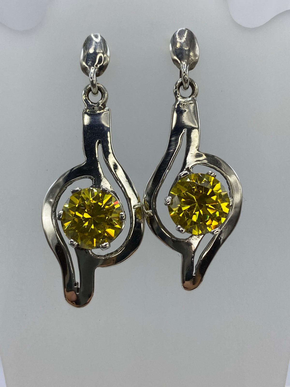 Vista lateral de los aretes mostrando el engaste de circonia amarillo en plata