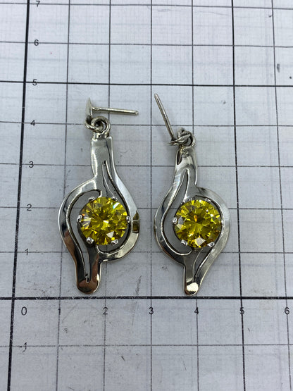 Aretes sobre fondo blanco con escala de centímetros, mostrando largo de 3.5 cm