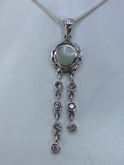 Dije de plata con perla blanca y circonia en forma de flor, colgando de cadena serpentín