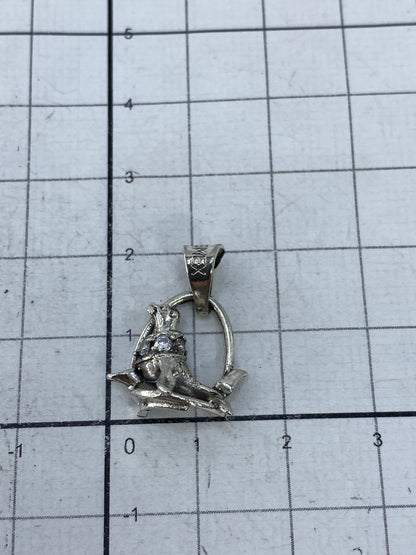 Dije foca de plata en la palma mostrando su tamaño miniatura
