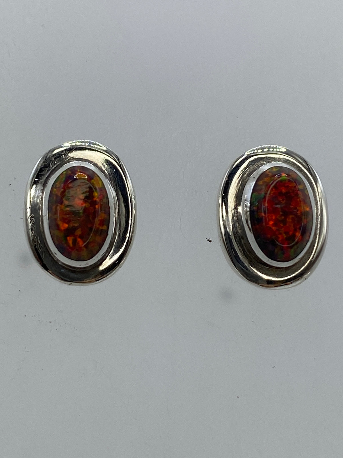 Par de aretes de plata 950 con ópalo de fuego multicolor, engastado a mano, sobre fondo gris