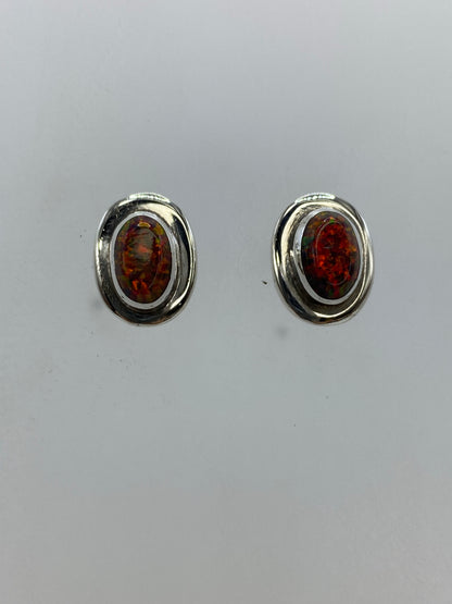 Detalle frontal de un arete mostrando el fuego y los reflejos del ópalo multicolor