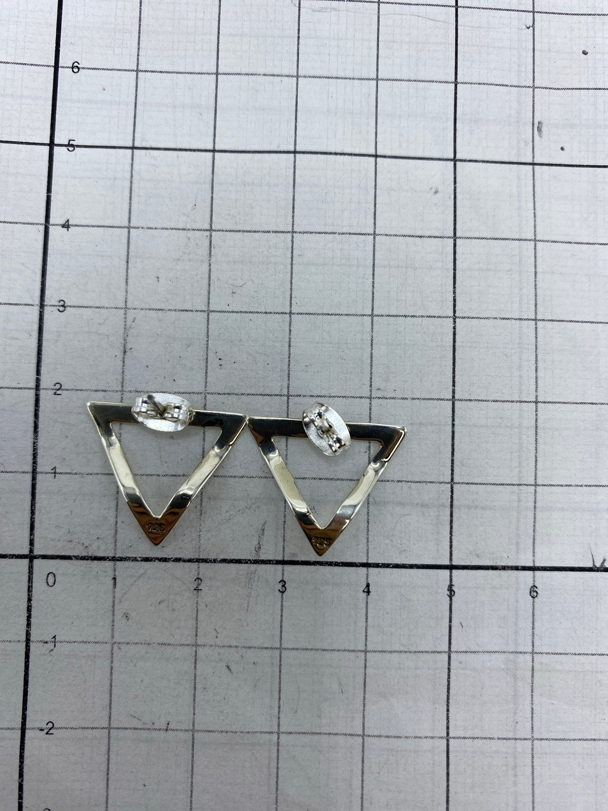 Aretes sobre fondo azul con el Quinto 925 visible en la base