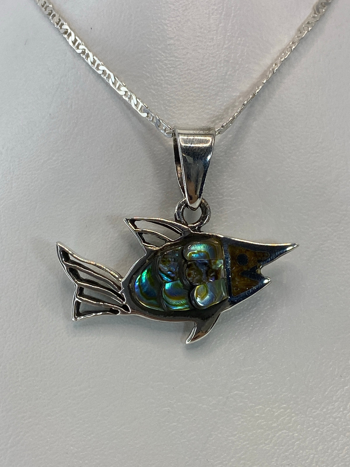 Detalle de la concha de abulón engastada, con destellos azul y verde