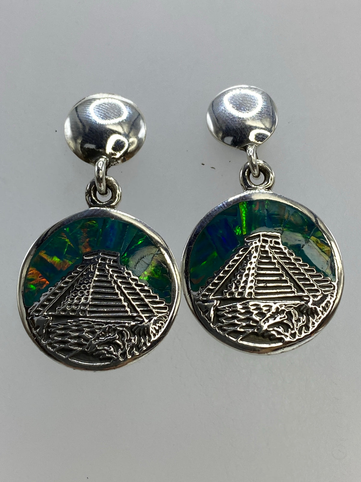 Detalle del engaste a mano del opalo de Fuego multicolor en los aretes