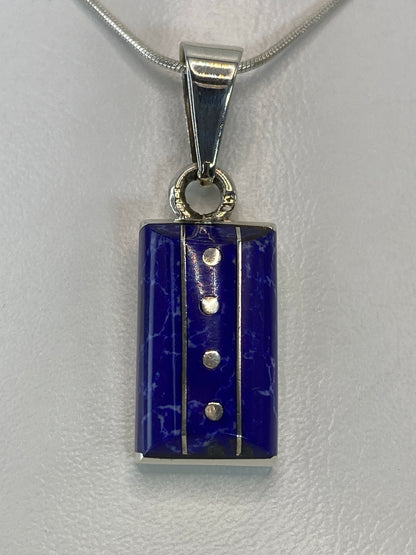 Dije de plata 925 con piedra azul engastada, colgando de cadena plateada