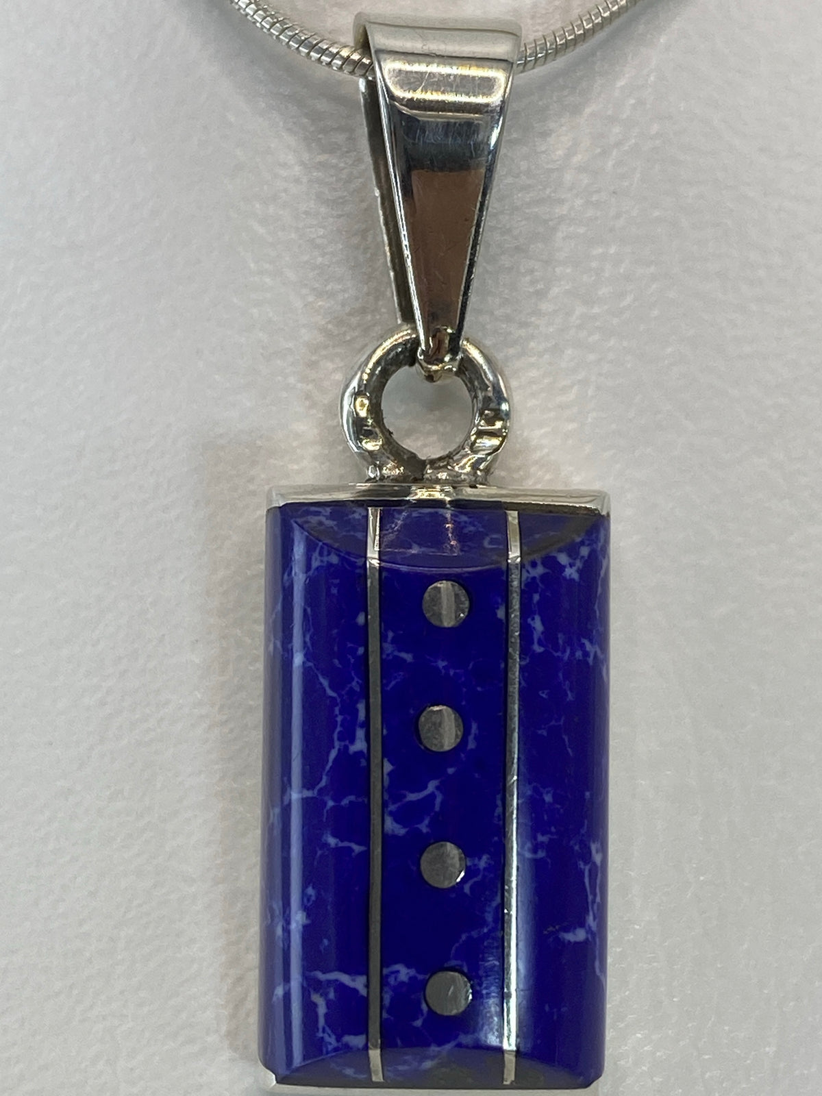 Detalle del engaste de piedra azul a mano en plata pulida
