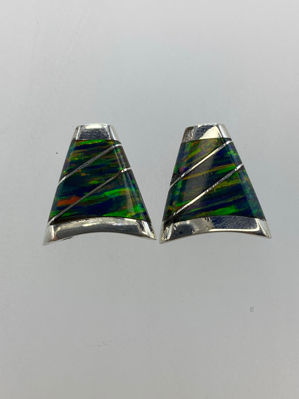 Aretes de ópalo de fuego mostrando los tonos verdes, azules y naranjas del juego de luz