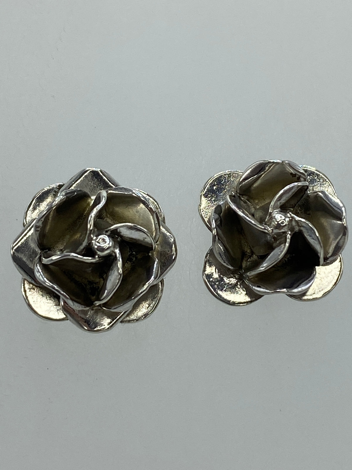 Aretes de plata sobre fondo azul mostrando el sello 925