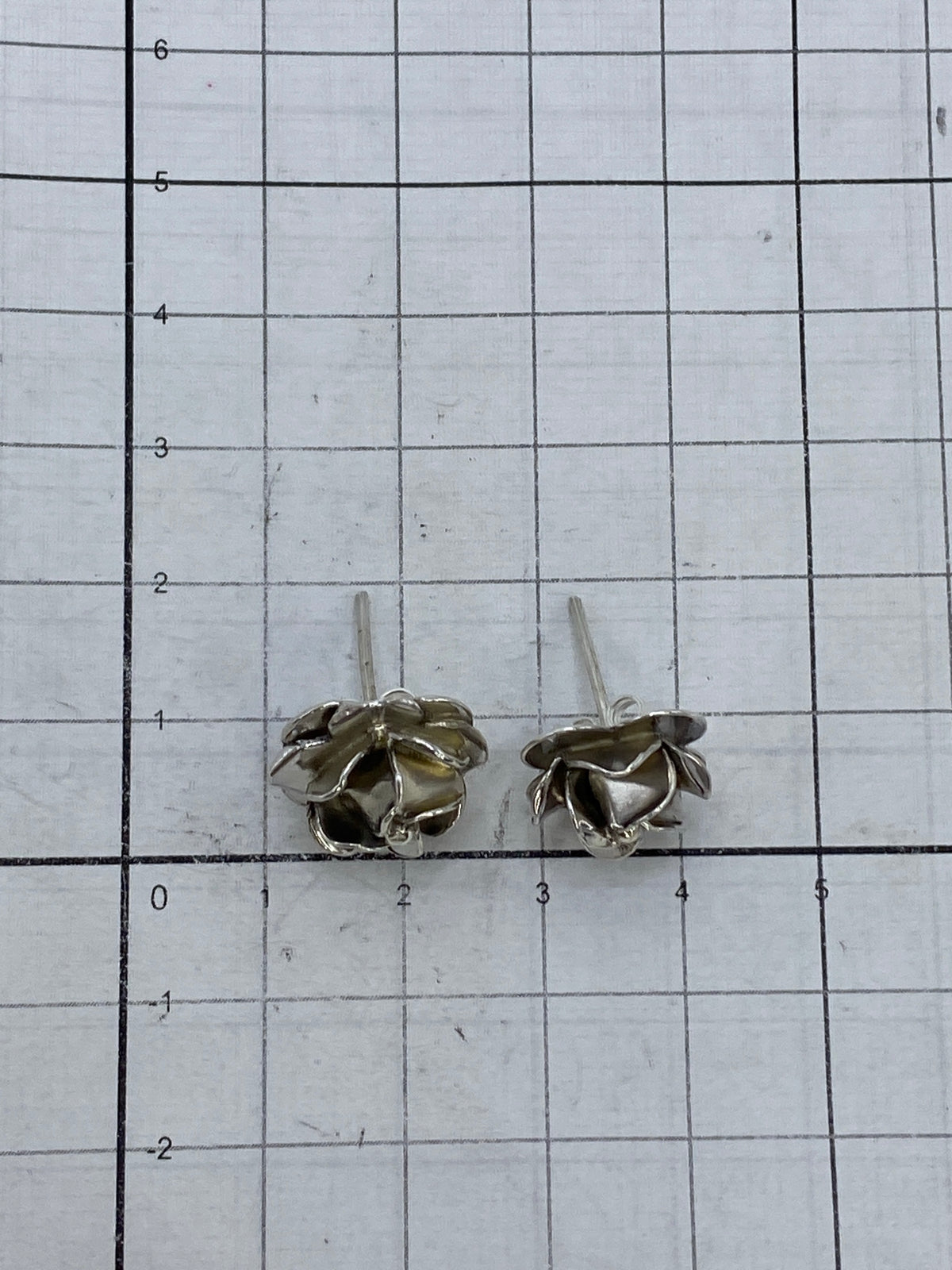 Aretes de rosa abierta de Taxco en la mano, pequeños y delicados