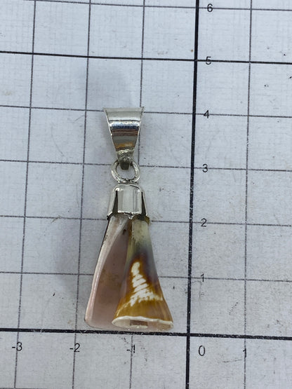 Dije de plata en escala con regla, midiendo 4 cm de largo