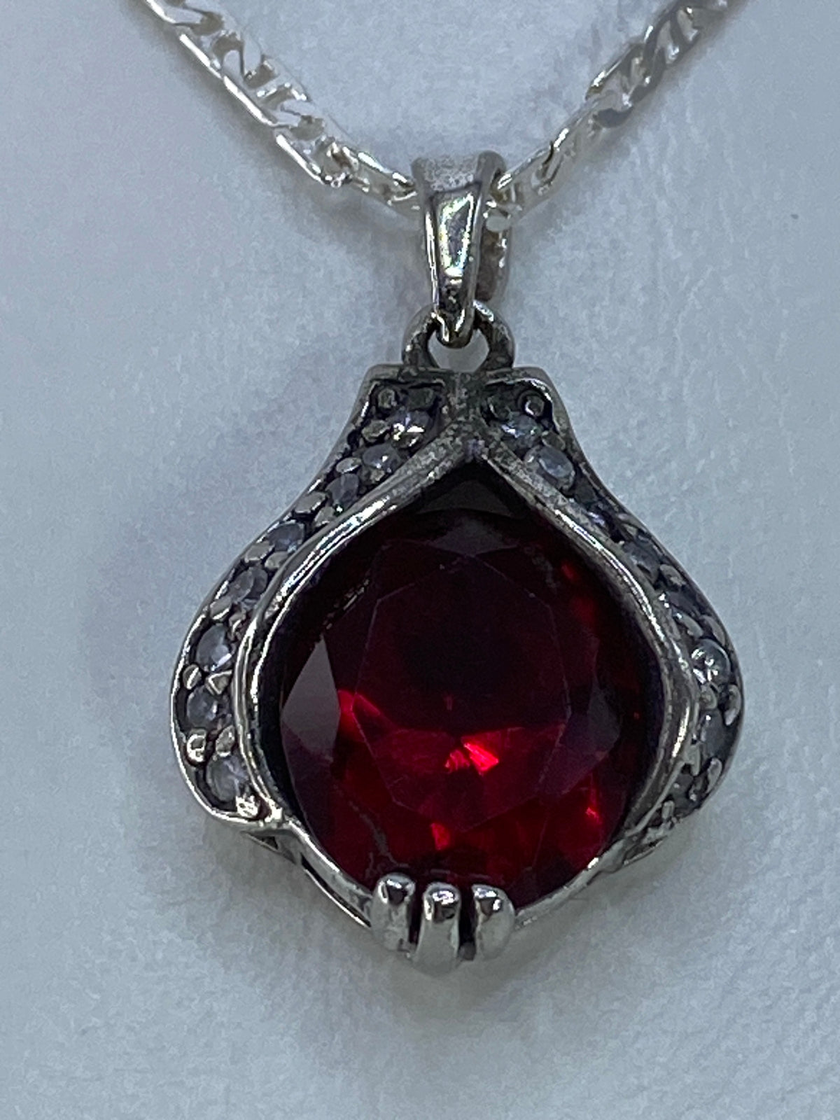 Dije de circonia roja al lado de regla métrica mostrando tamaño compacto de 2.2 cm