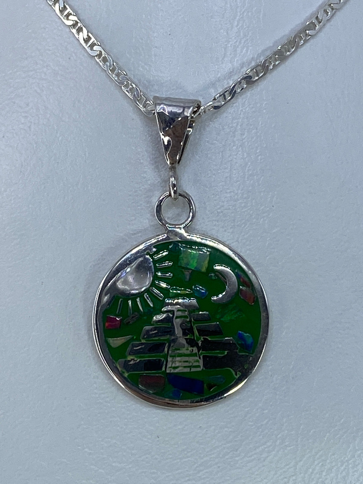 Dije de plata con ópalo de fuego multicolor engastado, colgando de una cadena plateada