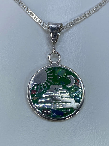 Detalle del ópalo de fuego multicolor en tonos verdes, rojos y azules dentro de la esfera de plata
