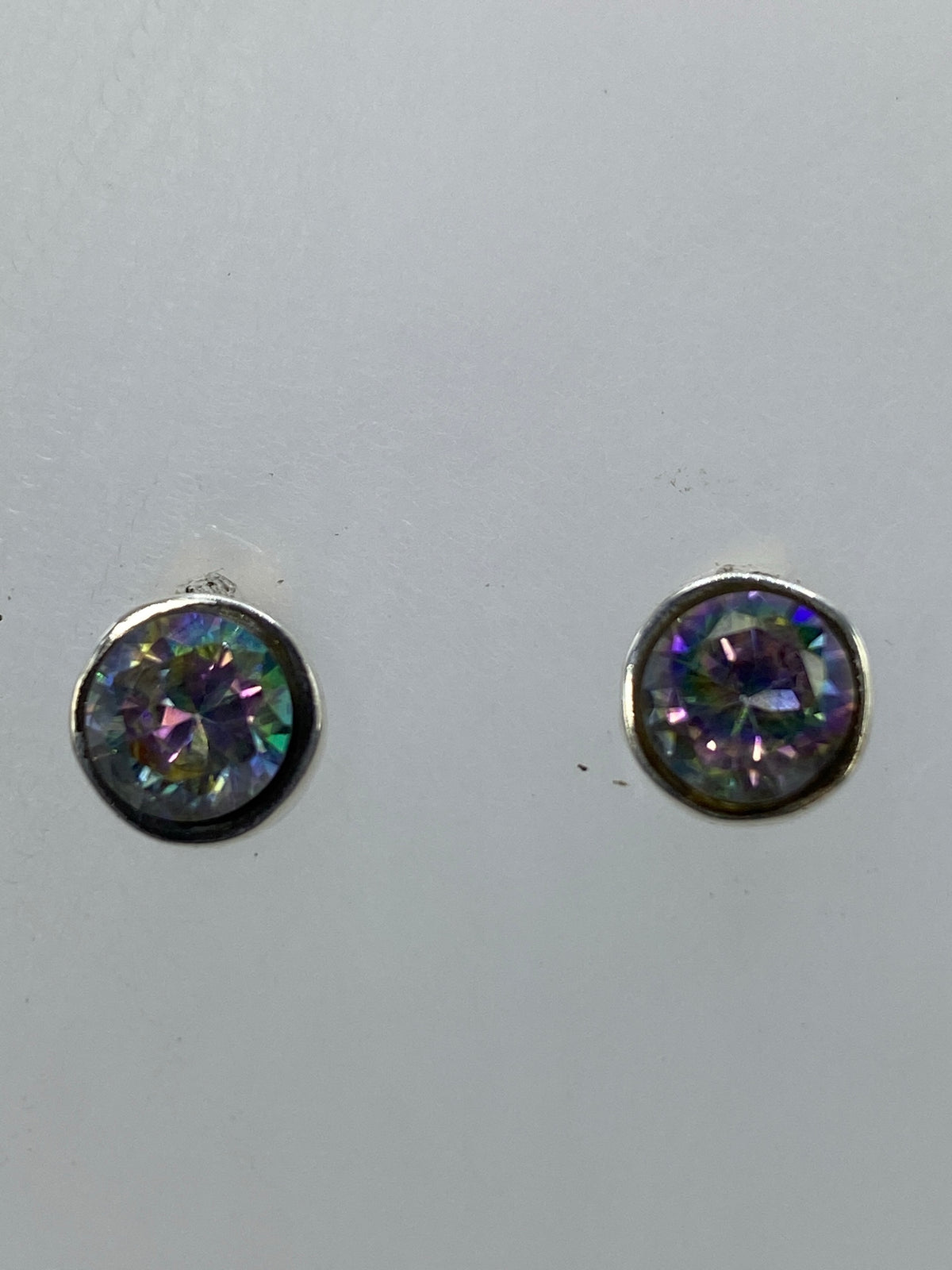 Aretes colgando, capturando la luz con tonos azul, púrpura y verde