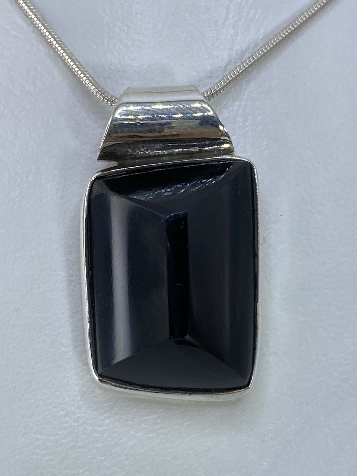 Dije de plata 925 con onix negro engastada, tamaño 2.8 cm sobre regla para escala