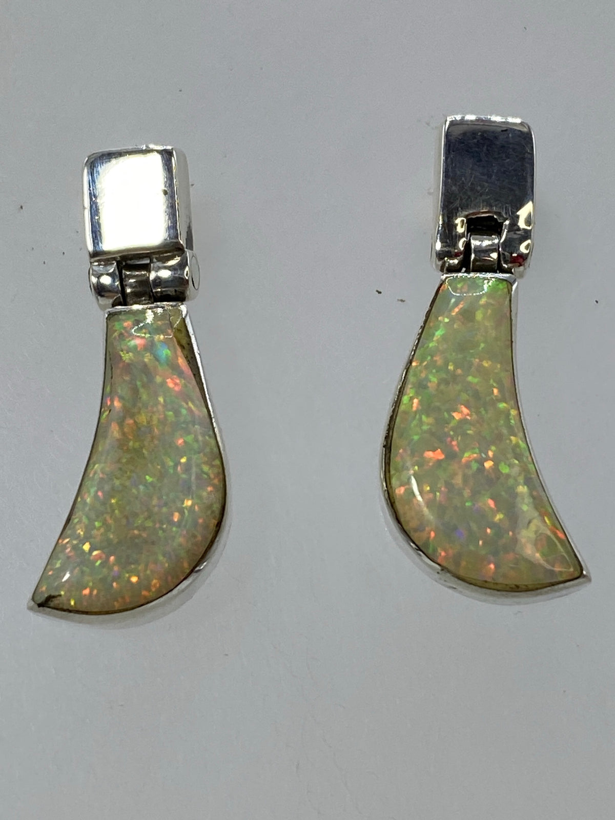 Aretes colgantes sobre fondo blanco, visible el Quinto 925 en la base de plata