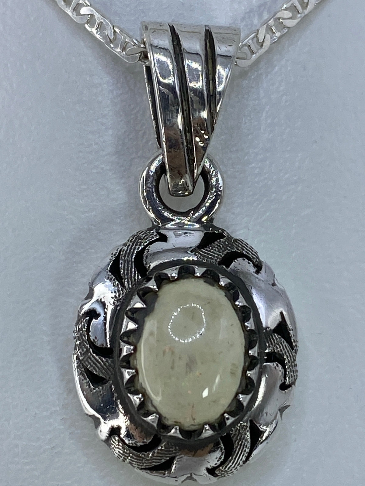 Detalle del engaste de piedra a mano en dije de plata Taxco 925