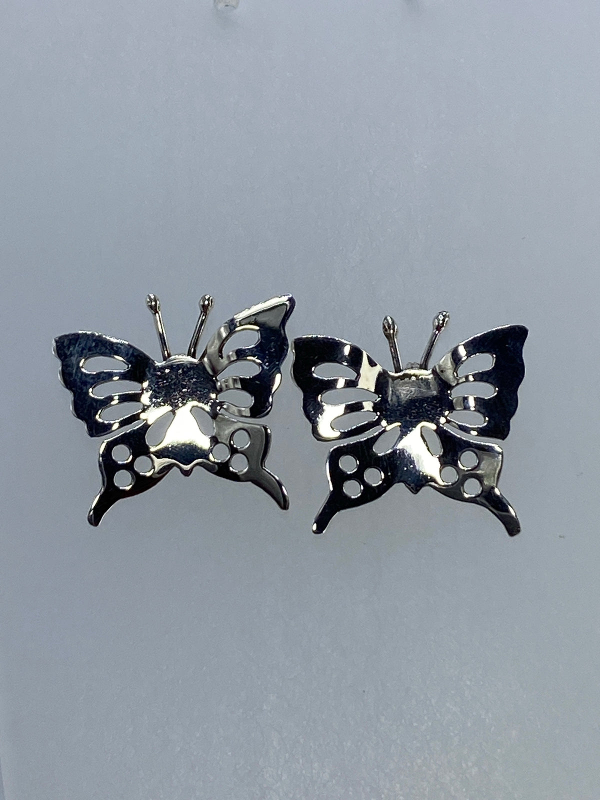 Aretes de plata 925 calados, mostrando el patrón geométrico de las alas