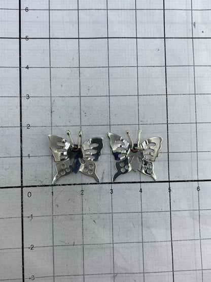 Aretes mariposa de plata sobre fondo blanco, tamaño y acabado real