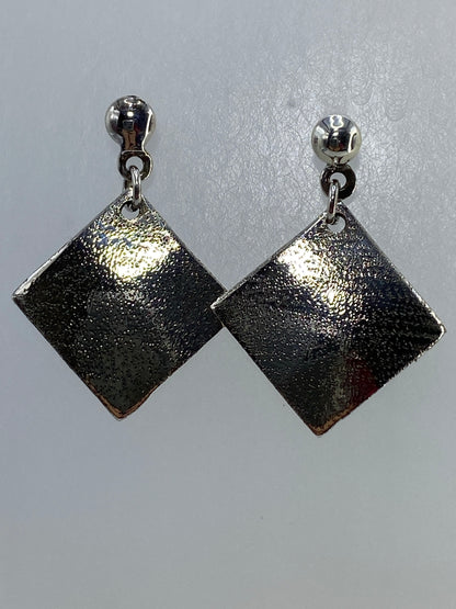 Par de aretes cuadrados de plata repujada, colgando de aros plateados