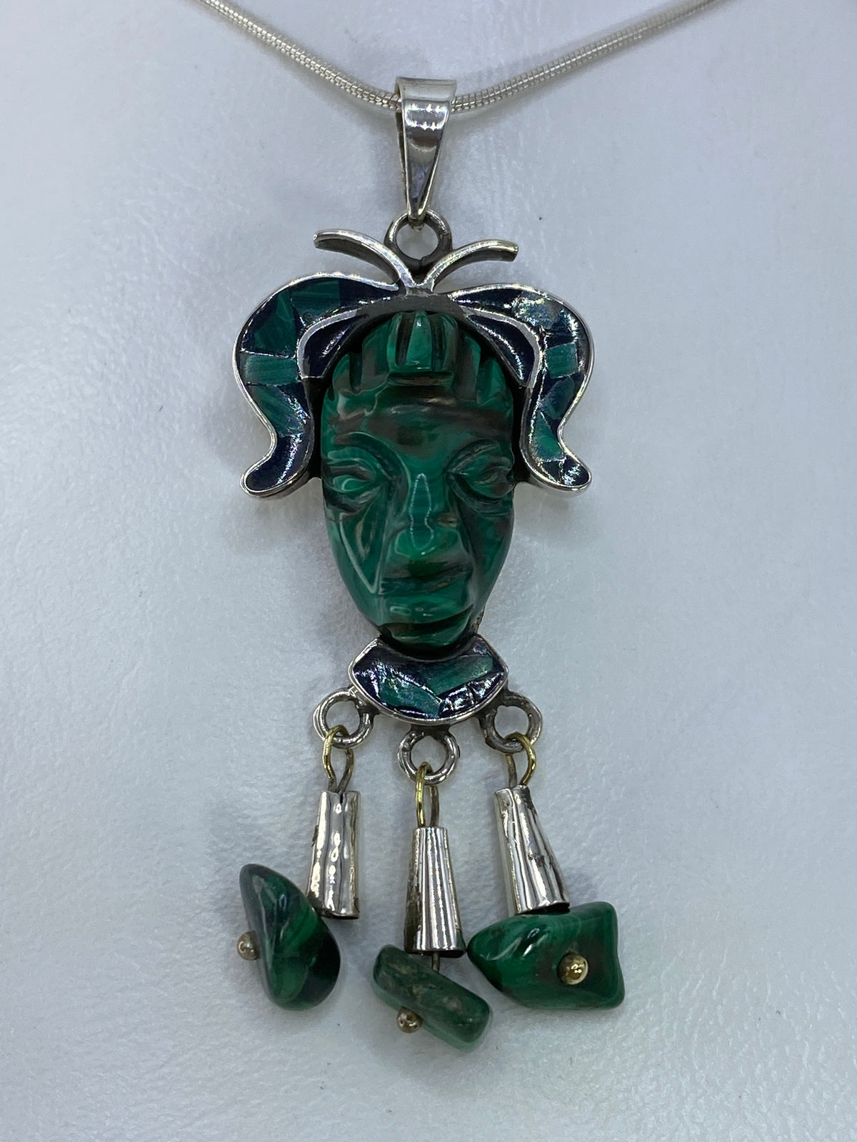 Detalle frontal del rostro prehispánico con malaquita verde incrustada
